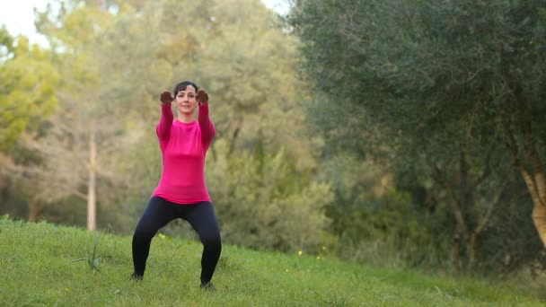 Žena, která dělá sportovní cvičení v parku - Záběry, video