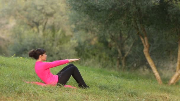 公園で腹部の運動をしている女性 - 映像、動画