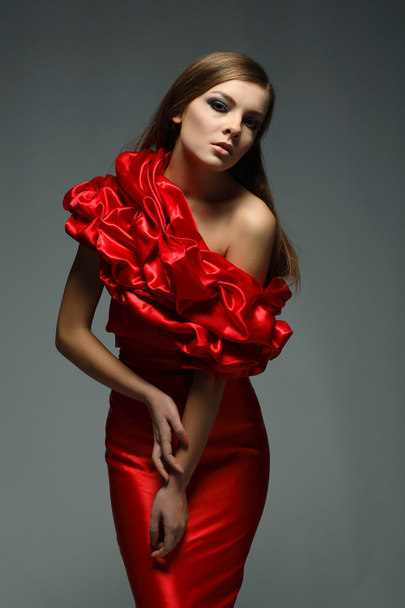 A beautiful young woman is in red clothes - Фото, изображение