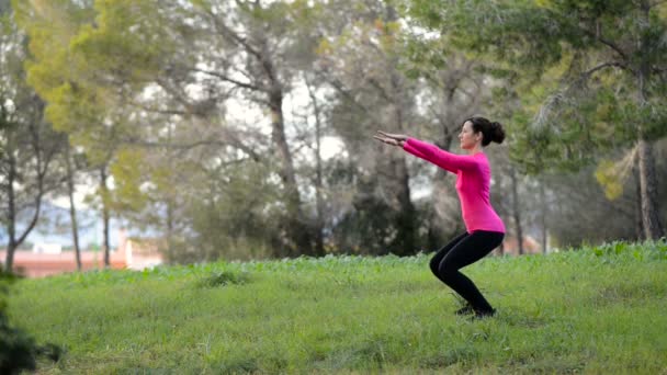 νεαρή γυναίκα κάνει αθλητισμό άσκηση στο πάρκο - Πλάνα, βίντεο