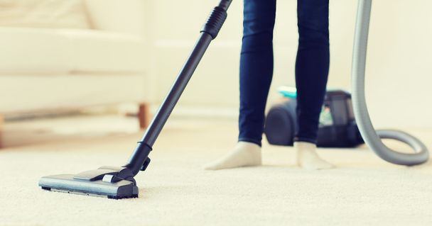 close up of woman legs with vacuum cleaner at home - Foto, Bild