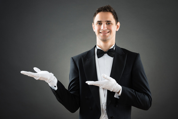 Confident Waiter Presenting Invisible Product - 写真・画像
