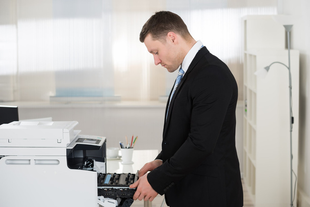 Businessman Adjusting Cartridge In Photocopy Machine - Foto, Bild