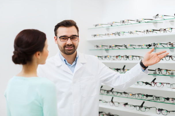 woman and optician showing glasses at optics store - Fotografie, Obrázek