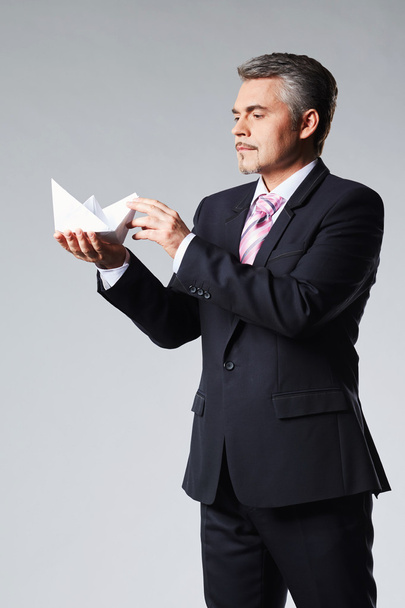 Portrait of businessman holding paper boat - Foto, imagen