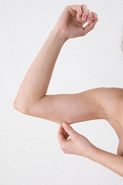 Mujer mostrando la parte superior del brazo suelto gracias a un estilo de vida poco saludable
. - Foto, Imagen