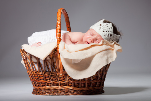 Newborn baby is sleeping on his stomach in a basket - Foto, Imagen