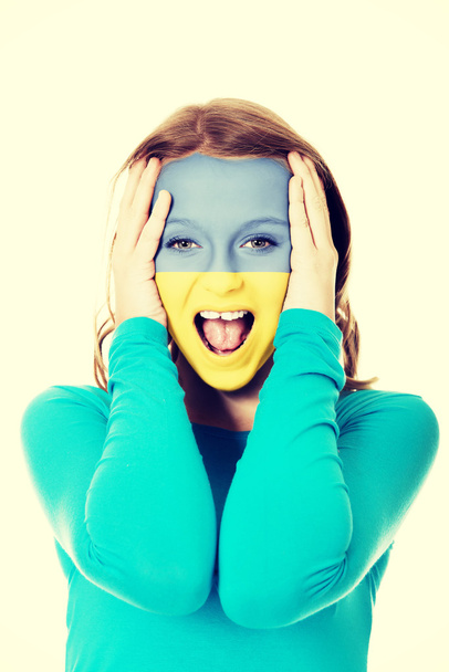 Woman with Ukraine flag on face. - Zdjęcie, obraz