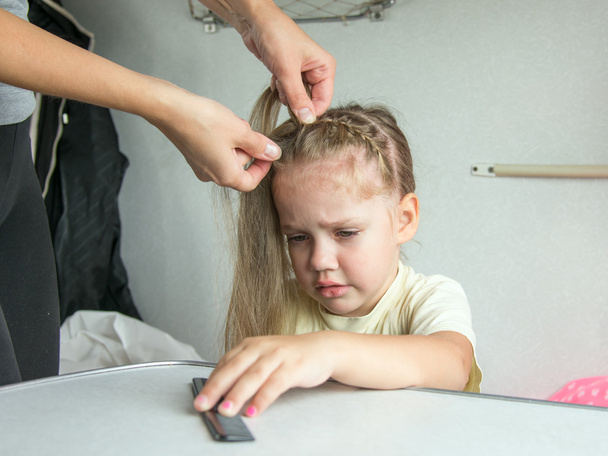 Chica de cuatro años llora de dolor cuando mi madre se peina el pelo
 - Foto, Imagen