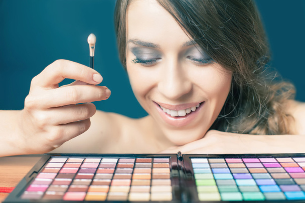 Happy woman with colorful palette for fashion makeup - Fotó, kép