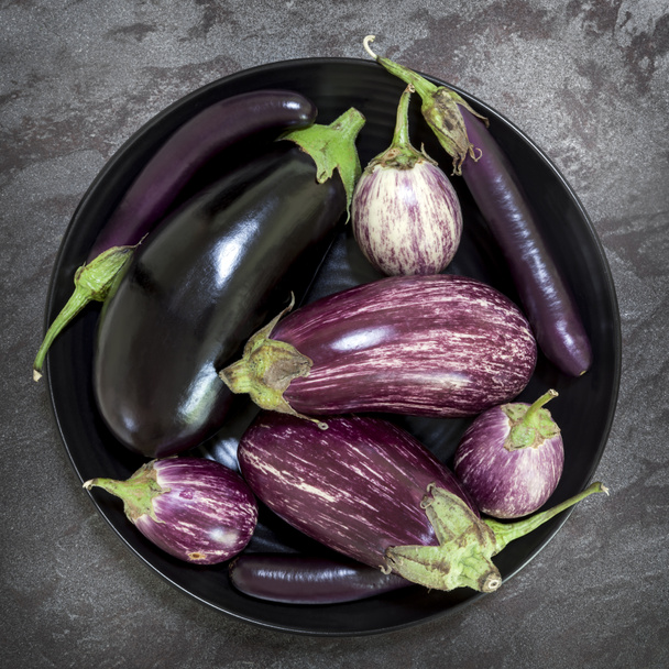 Eggplant Varieties in Black Bowl on Slate Overhead View - Photo, Image