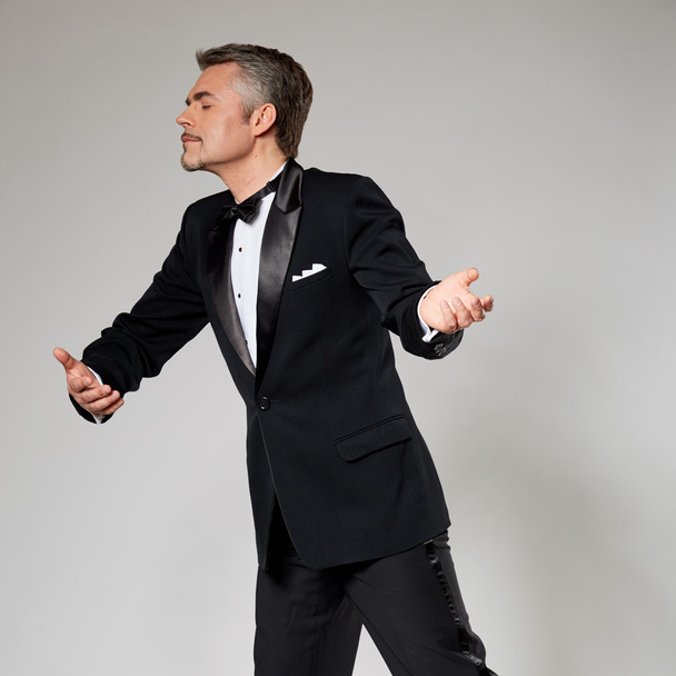 businessman in elegant suit dancing with an imaginary woman - Fotoğraf, Görsel