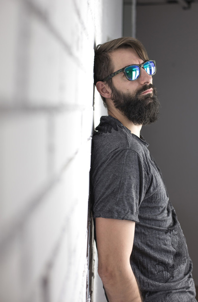 Hipster. Portrait of a bearded young man with green sunglasses - Foto, Bild