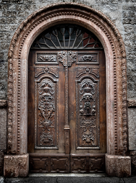 Старые деревянные ворота с выгравированными демоническими фигурами
. - Фото, изображение