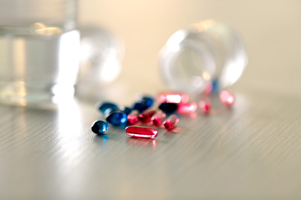 Pile of blue and red capsules on table - Valokuva, kuva