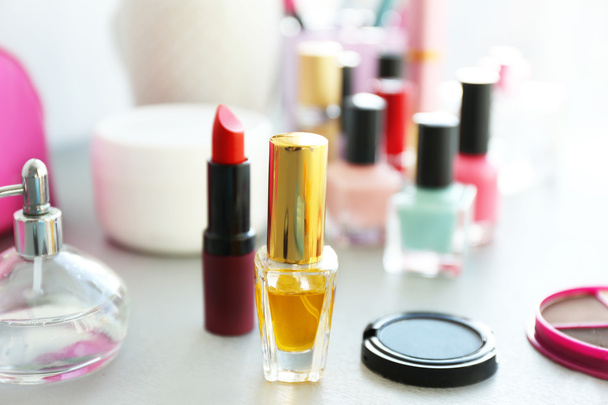 Perfume bottle with makeup cosmetics on a table - Zdjęcie, obraz