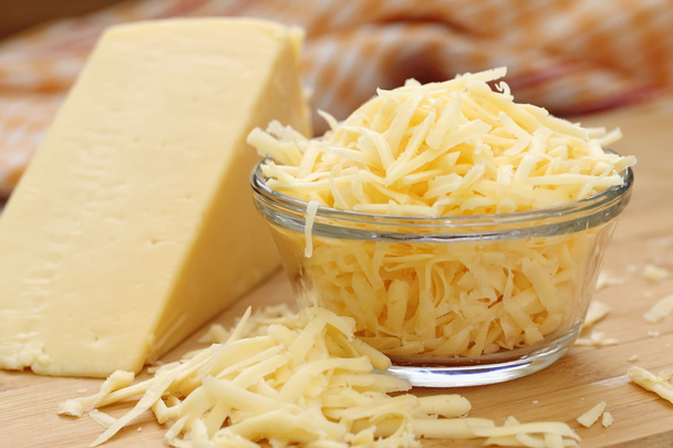Тертий сир у скляній мисці
 - Фото, зображення