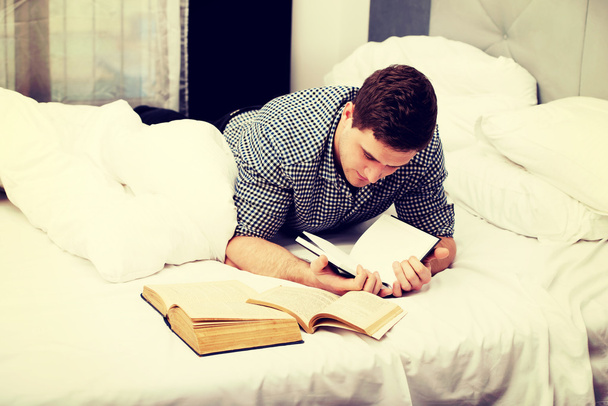 Thoughtful man with a book in his bed. - Foto, imagen