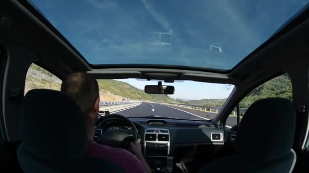 man met een auto op het platteland road trip in de natuur - Video