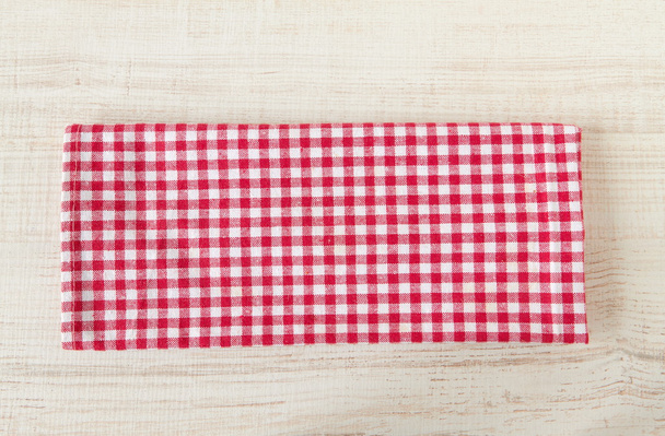 Red towel over wooden kitchen table. - Photo, Image