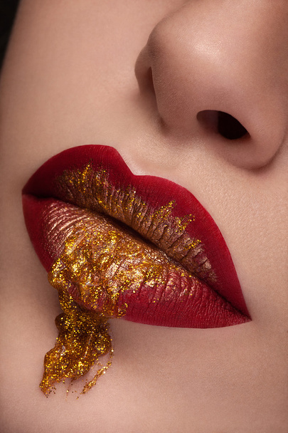 Закройте губы красными, с золотой жидкостью из губ
 - Фото, изображение
