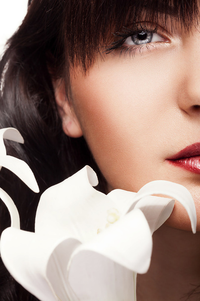 Femme fraîche avec peau parfaite et orchidée devant le visage
 - Photo, image