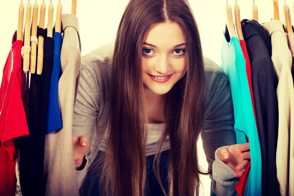 Teen woman between clothes on hanger. - Photo, Image