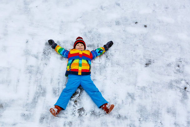 Małe dziecko chłopiec, co Anioł śniegu w zimie, na zewnątrz - Zdjęcie, obraz