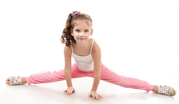 Cute little girl doing gymnastic exercise - Foto, afbeelding