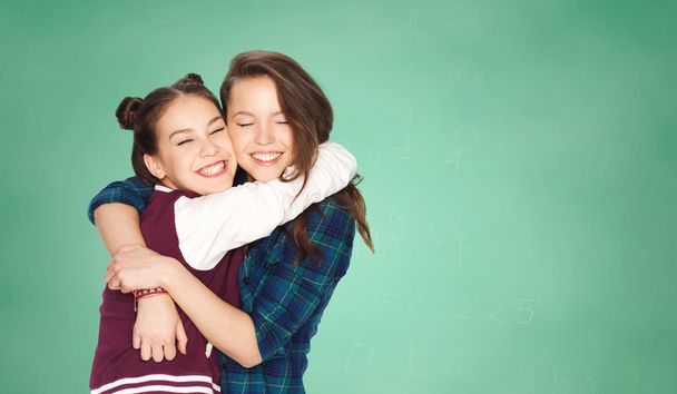 happy teenage girls hugging over green board - Fotografie, Obrázek