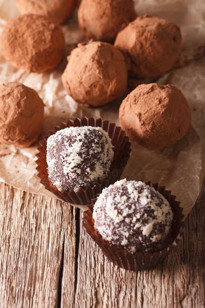 Chocolate truffles on a paper close-up on a table. vertical - Photo, Image