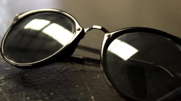czarne okulary na stole - Materiał filmowy, wideo
