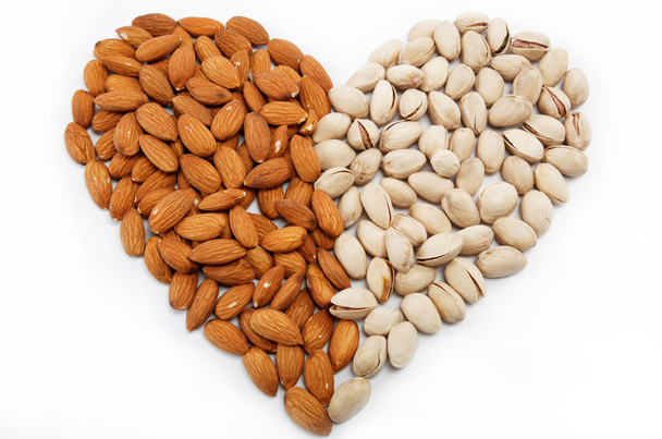 The image of the heart of the almond and pistachio nuts. - Фото, изображение