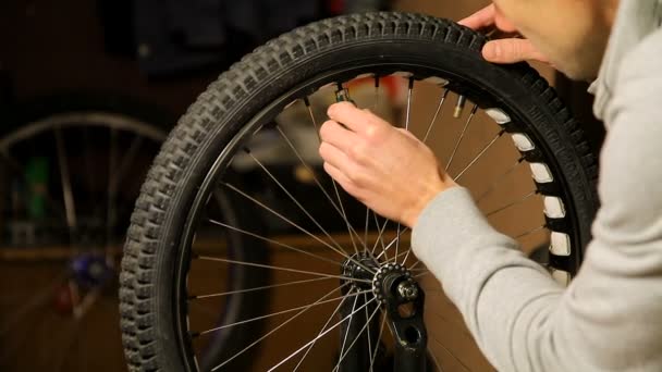 Bike maintenance. the young man tightens the spokes on the Bicycle wheel. - Filmagem, Vídeo