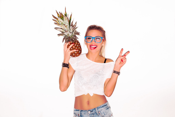 woman in glasses with pineapple showing tongue - Foto, afbeelding