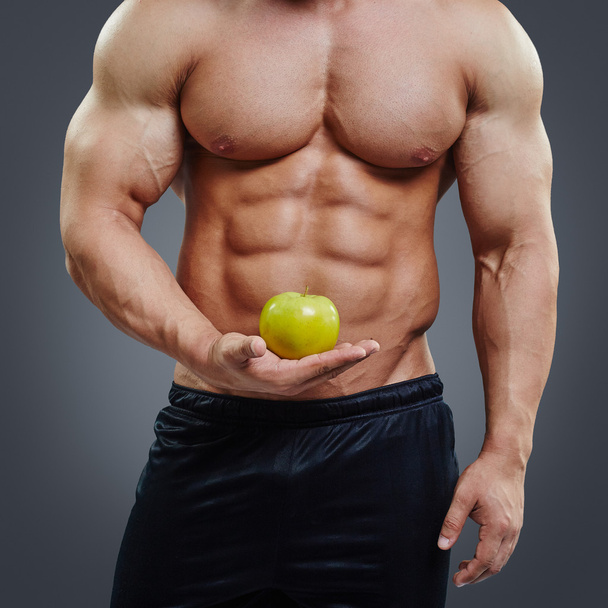 Shirtless muscular man holding a fresh apple - Foto, Imagem