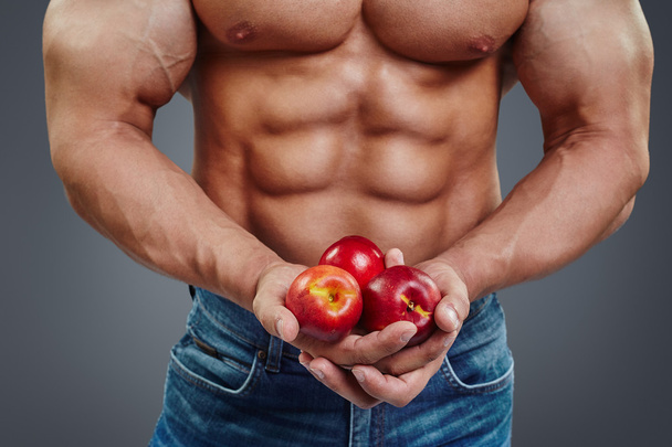 man bodybuilder hands holding a fresh peaches - Foto, Bild