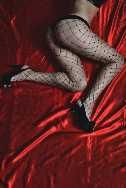 Beautiful girl in stockings and shoes on a bed. Popa closeup. - Foto, Imagen