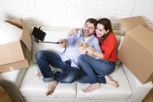 glückliches Paar auf der Couch, das gemeinsam Champagner feiert  - Foto, Bild