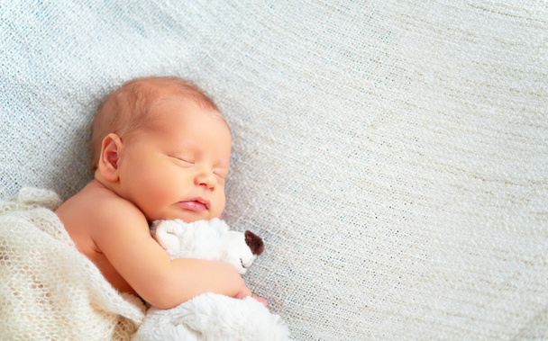 Aranyos újszülött baba alszik játék mackó  - Fotó, kép