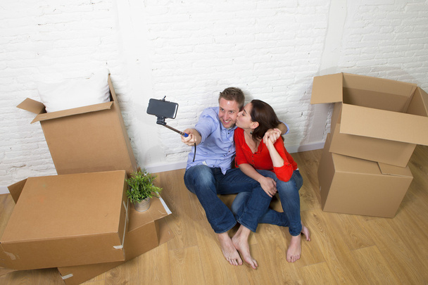 young happy couple sitting on floor celebrating moving in new ho - 写真・画像