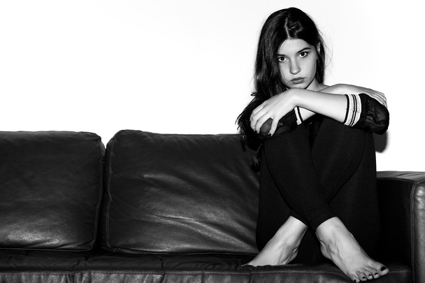 Girl portrait sitting on the sofa black and white - Φωτογραφία, εικόνα