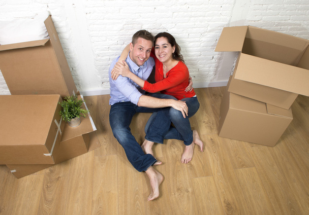 young happy couple sitting on floor celebrating moving in a new  - Photo, Image