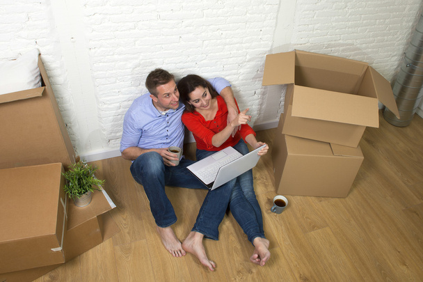 пара, сидящая на полу, переезжающая в новый дом или квартиру
  - Фото, изображение