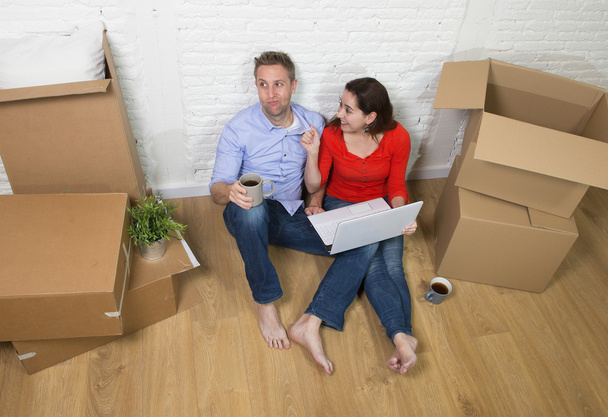 couple assis sur le sol se déplaçant dans une nouvelle maison ou appartement appartement
  - Photo, image