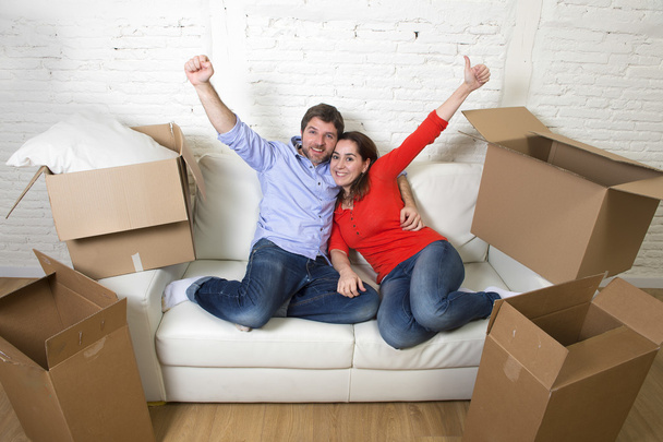 happy American couple lying on couch together celebrating moving - Фото, зображення