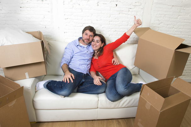 happy American couple lying on couch together celebrating moving - Φωτογραφία, εικόνα