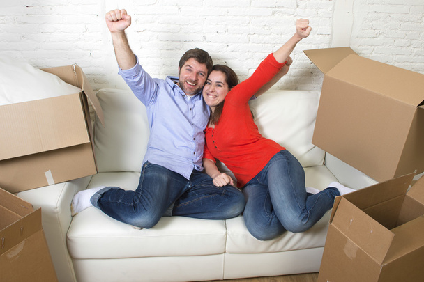 happy American couple lying on couch together celebrating moving - 写真・画像