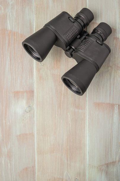 Binoculars on a natural blue wood surface. Top view with copy sp - Photo, Image