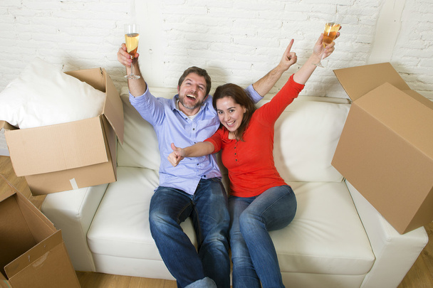 счастливая американская пара, лежащая вместе на диване и празднующая переезд
 - Фото, изображение